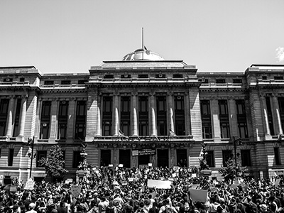 A state building with activists on its steps.